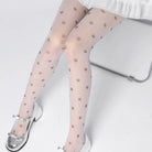 Sheer tights with paw print pattern worn by a person sitting on a chair.