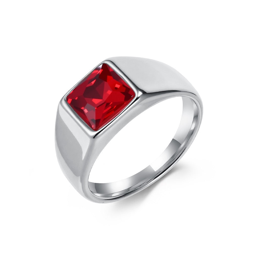 Silver ring with a red gemstone on a white background