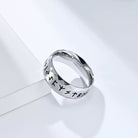 Silver ring with engraved text on a light gray background