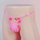 Pink lace thong with floral design on a mannequin against a light gray background