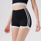 Black athletic shorts with white stripes on a plain background