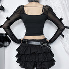 Black outfit with sheer sleeves and layered skirt on a white background