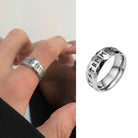 Silver ring with engraved text worn on a finger, next to a close-up of the ring on a white background.