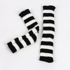 Black and white striped arm warmers on a light gray background
