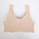 A beige seamless sports bra with a textured, breathable mesh-like fabric, laid flat against a clean white background.