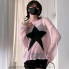 A femboy wearing a light pink chunky knit sweater with a large black star graphic on the front, paired with a black face mask and black sequined bottoms, standing in front of white curtains.