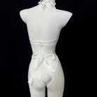 White lingerie set on a mannequin against a black background