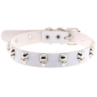 A white faux leather collar decorated with multiple silver skull studs, shown against a plain white background.