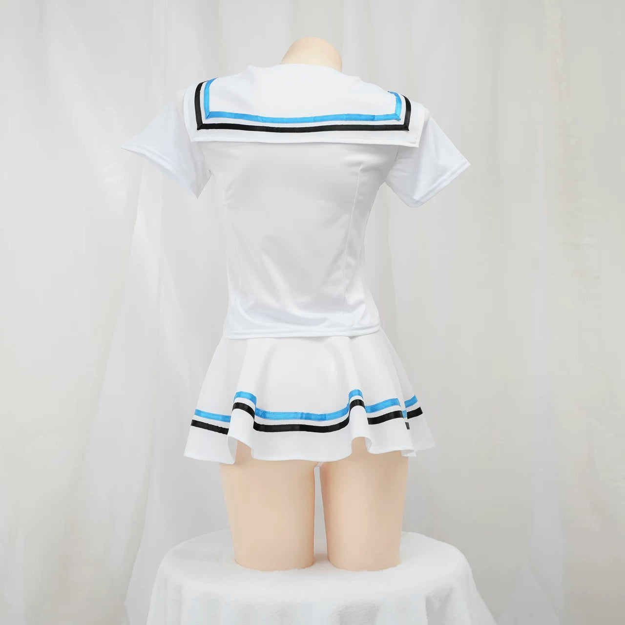 White sailor lingerie set with blue and black trim on a mannequin against a white background