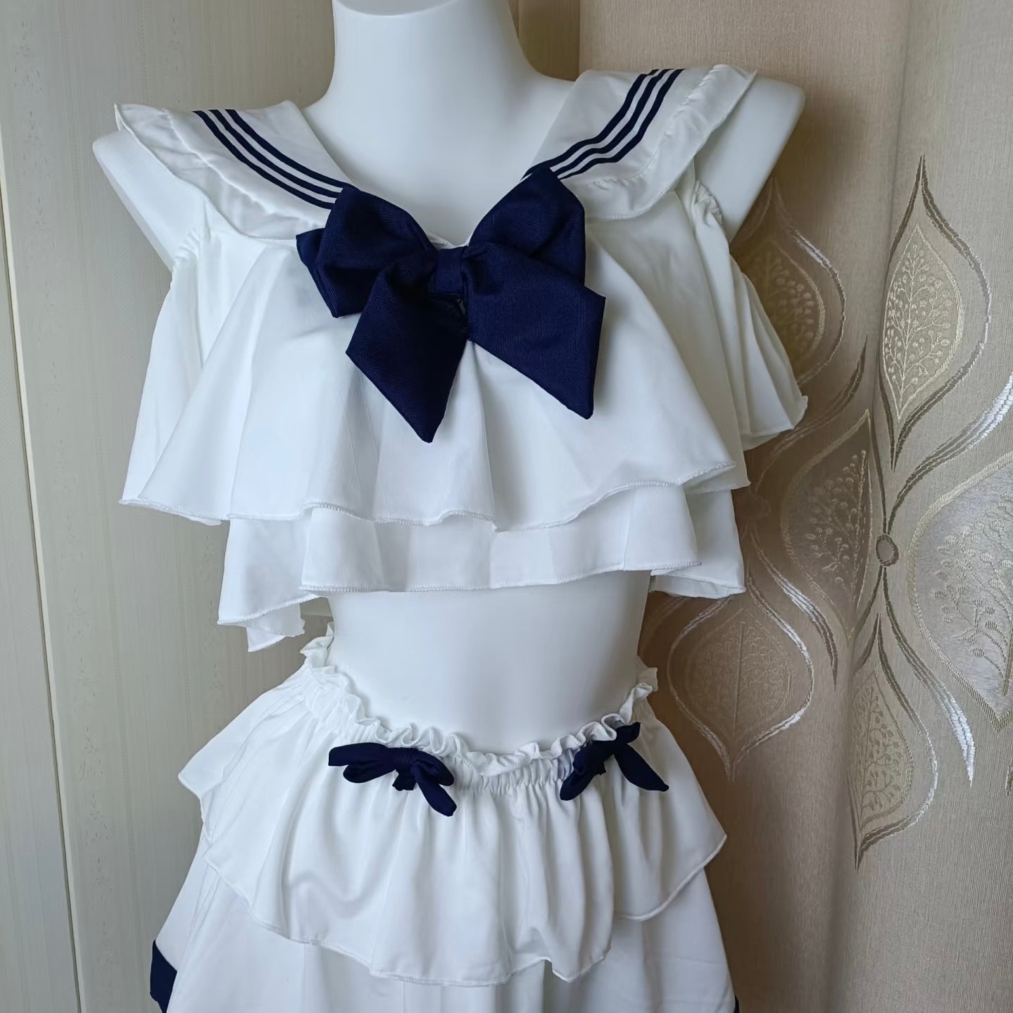 White sailor lingerie set with blue accents on a mannequin against a white background