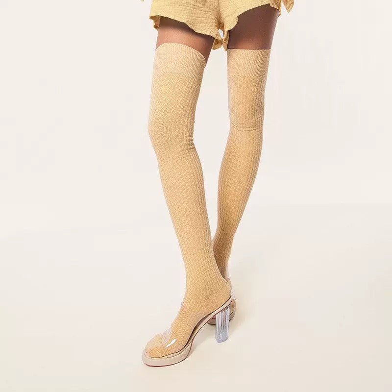 Yellow thigh-high socks with clear high-heeled shoes on a light beige background
